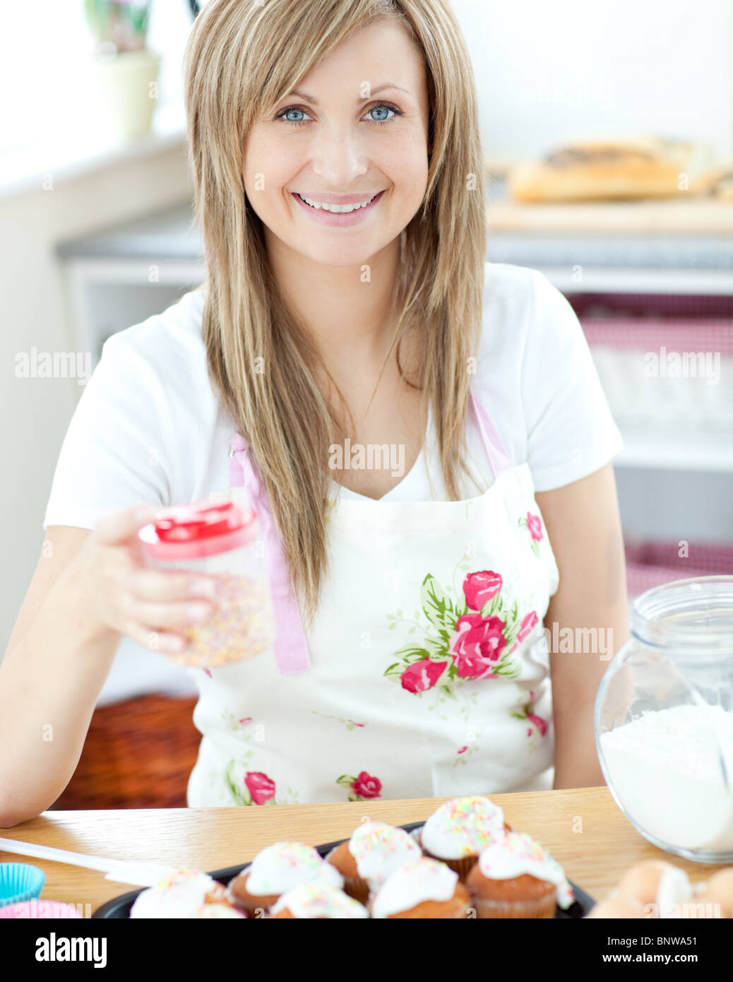 Attraktive Frau mit Kuchen in der Küche Stockfoto