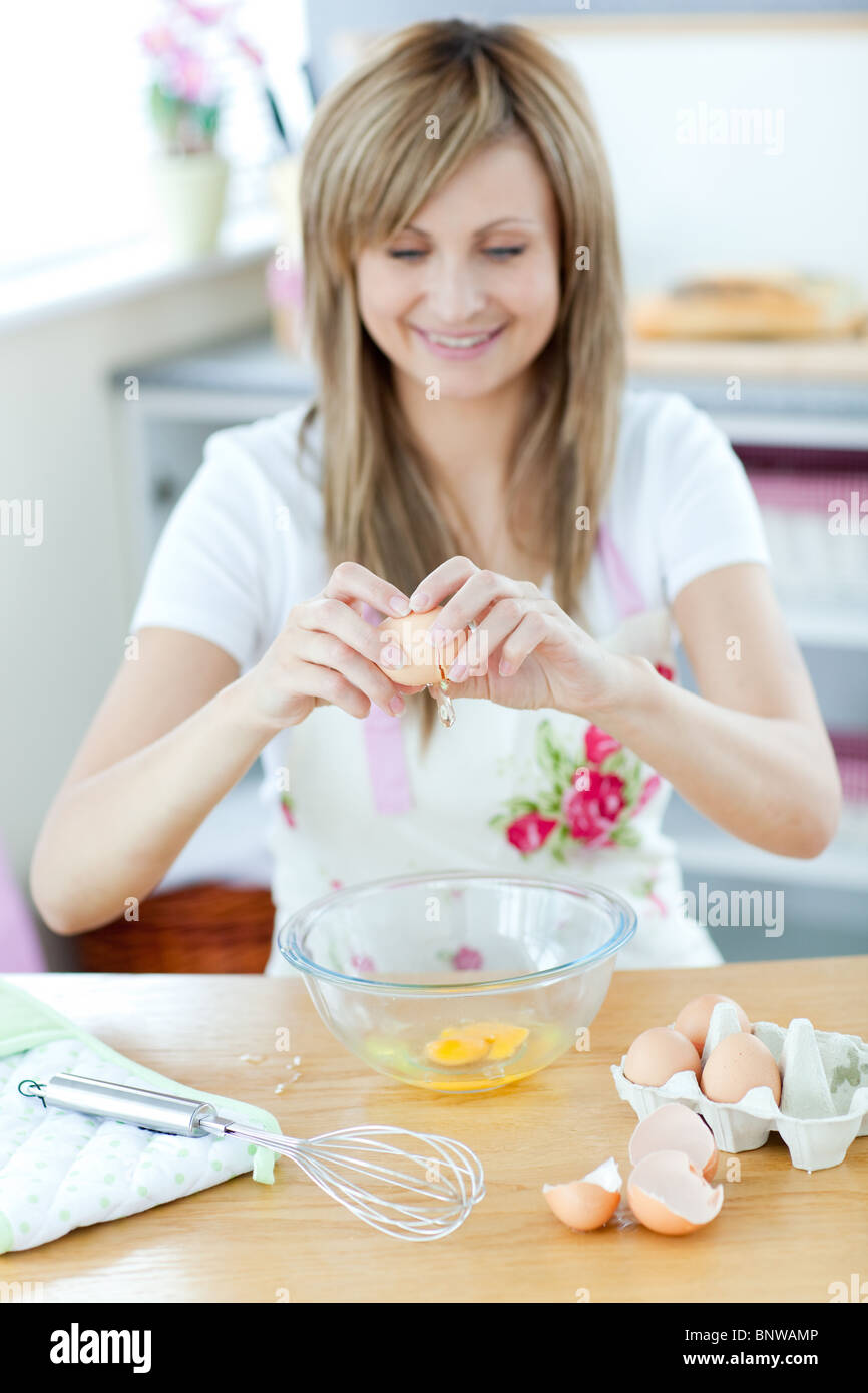 Hübsche Frau, die einen Kuchen in der Küche vorbereiten Stockfoto