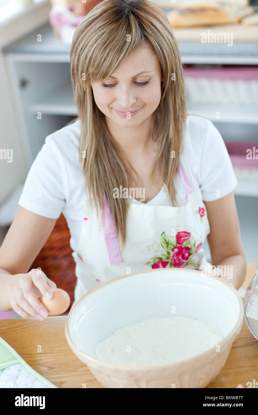 Porträt von eine glückliche Frau, die einen Kuchen in der Küche vorbereiten Stockfoto