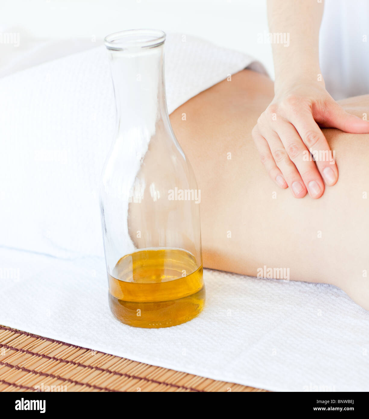 Nette Frau mit einer Massage mit Massageöl Stockfoto