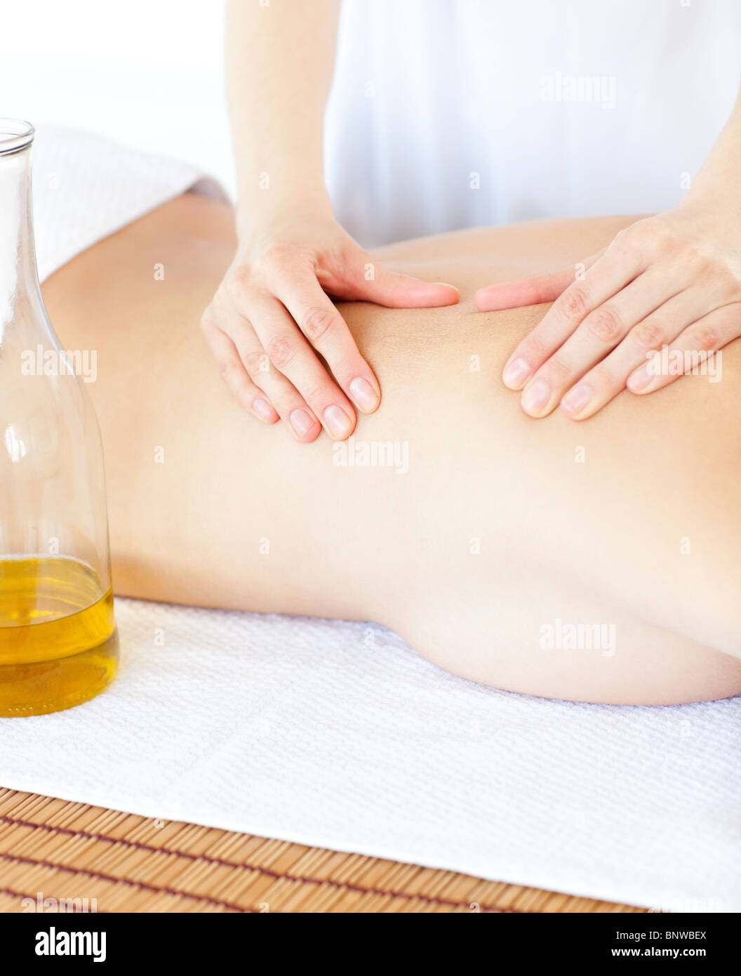 Attraktive Frau mit einer Massage mit Massageöl Stockfoto