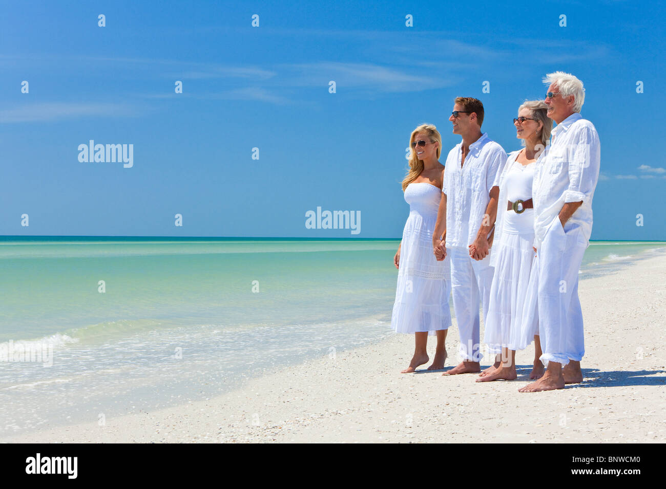 Zwei Paare, Generationen einer Familie zusammen Hand in Hand an einem tropischen Strand Stockfoto