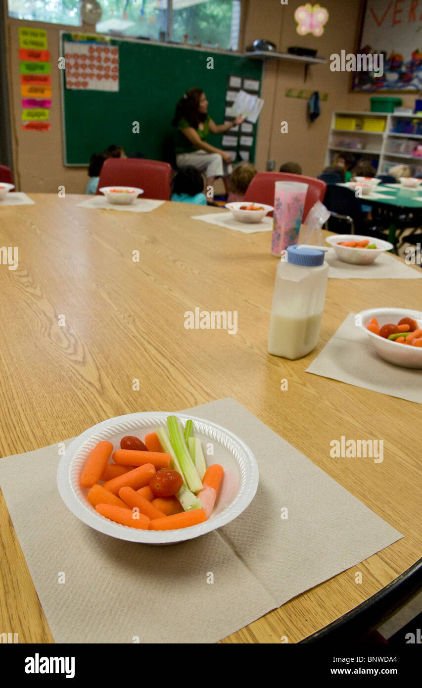 gesunde Snacks mit Karotten, Tomaten und Sellerie auf Tisch für Kinder im Klassenzimmer an privater zweisprachiger Kindergarten Stockfoto