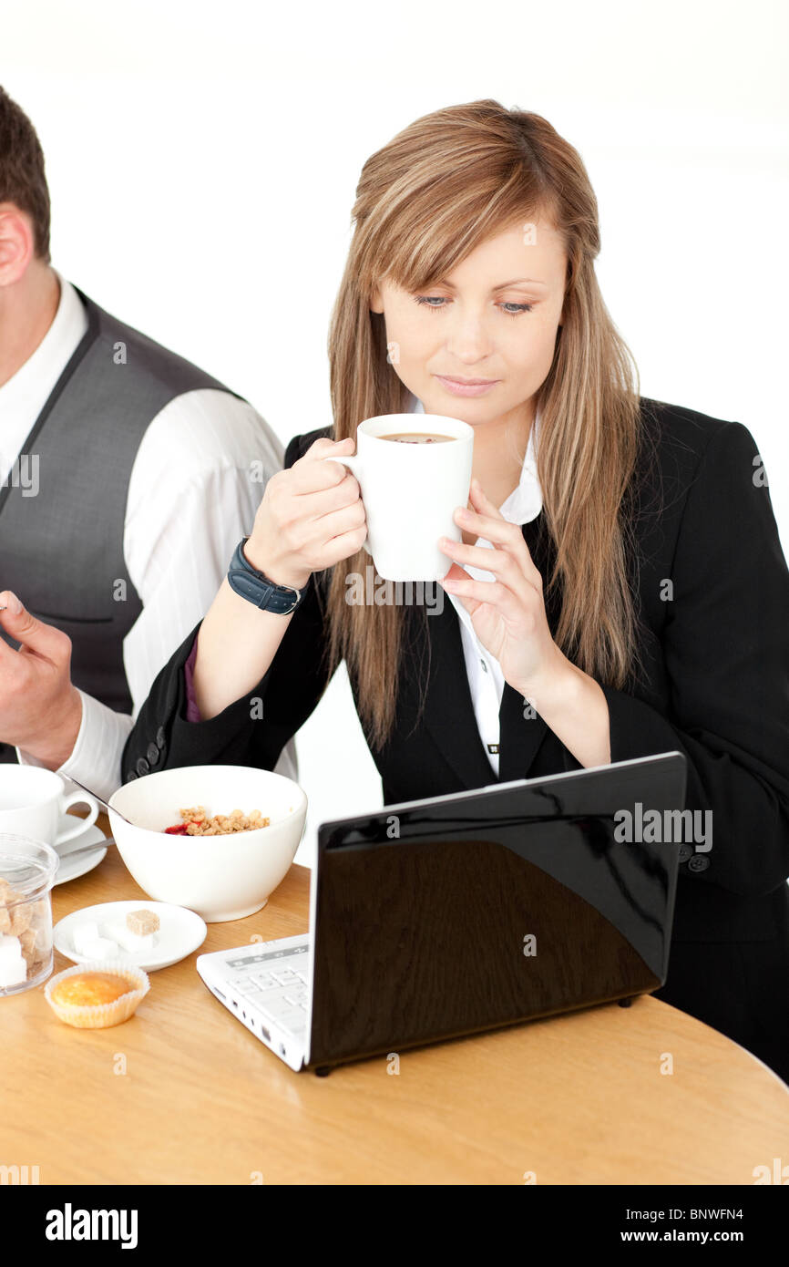 Ernsthafte Geschäftsfrau mit einem Laptop beim Frühstück Stockfoto