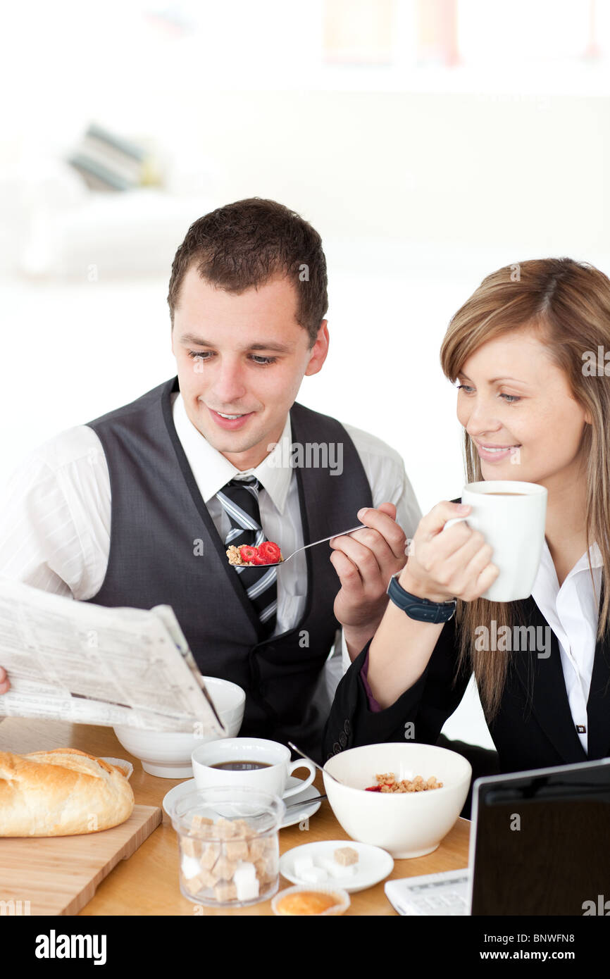 Lächelnde paar Geschäftsleute lesen eine Zeitung beim Frühstück Stockfoto