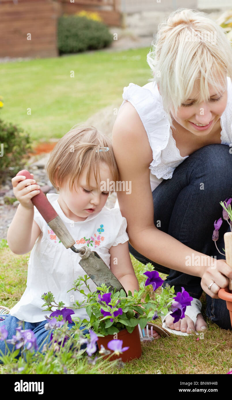 Kleines Mädchen mit lila Blüten Stockfoto