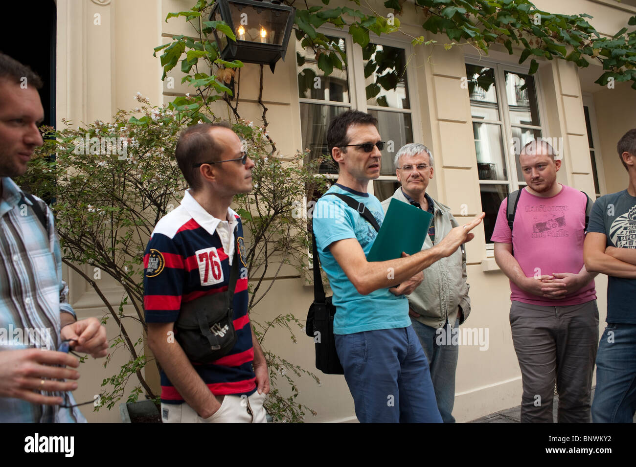 Touristengruppe für Erwachsene, die eine geschichtsträchtige Tour durch Paris aus den 1980er Jahren mit dem Reiseleiter macht Hervé Taulière. Marais District, („Herve le Tapie“) Stockfoto
