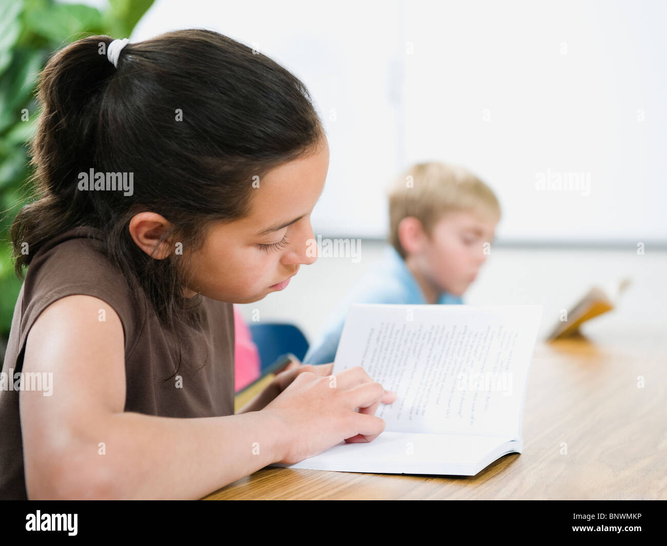Grundschüler lesen Bücher am Schreibtisch Stockfoto