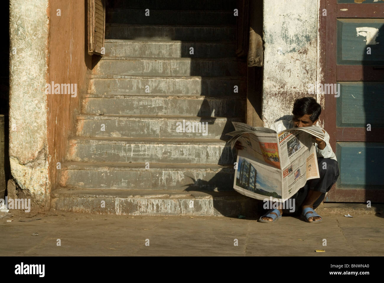 Mann liest Free Press Zeitung, Crawford Market, Mumbai, Indien Stockfoto