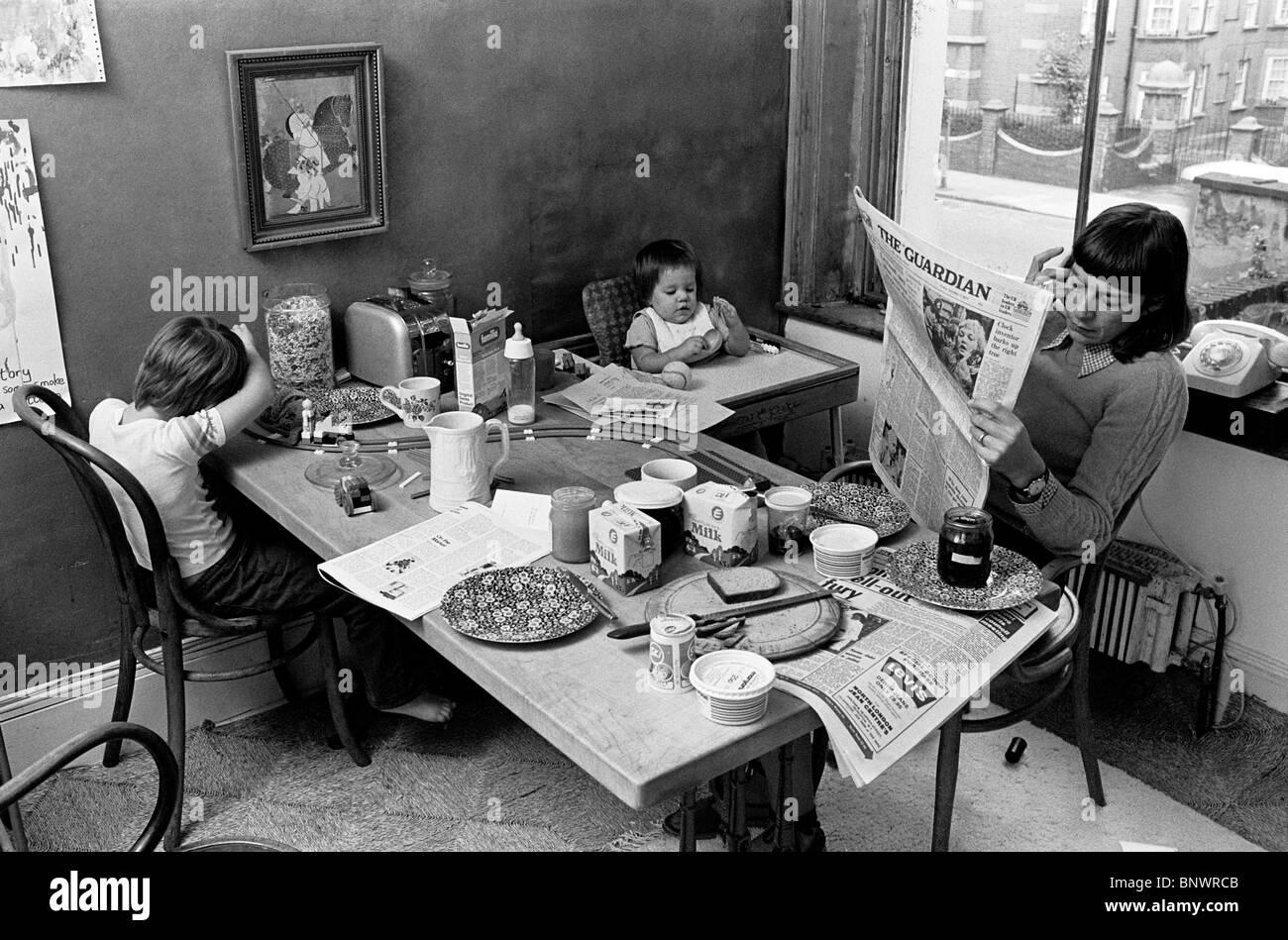 "schwarz-weiß" historisches Bild der Mutter mit 2 Kindern beim Frühstück Stockfoto