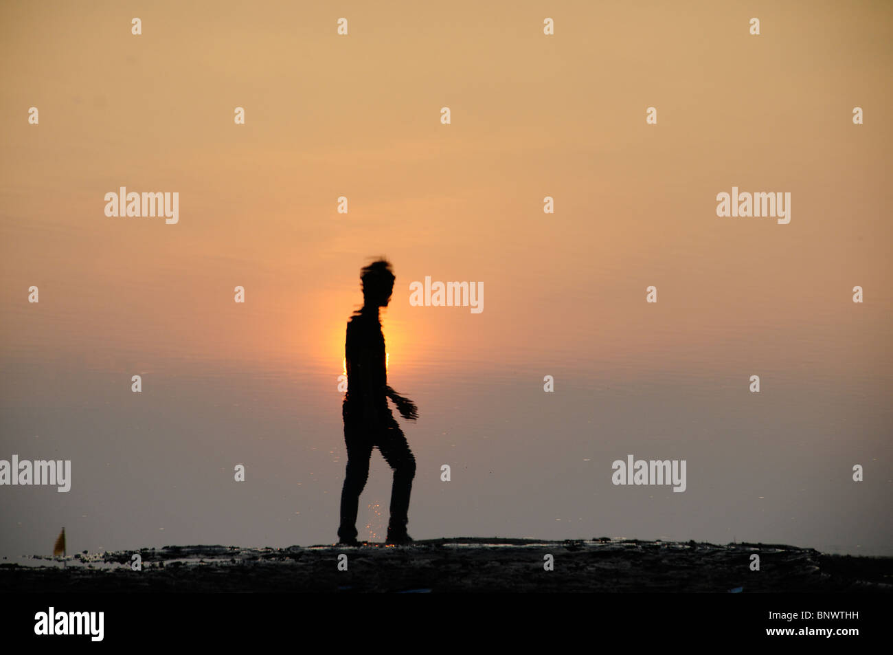 Silhouette Reflexion eines jungen Mannes bei Sonnenuntergang am Mekong river Stockfoto