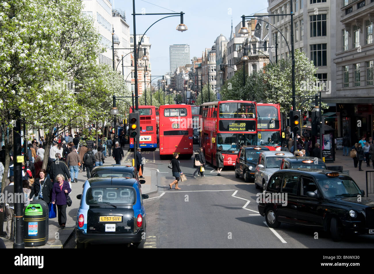 Busse und Taxis die Oxford Street, wohingegen Shopper drängen sich die Bürgersteige. Gesehen von einem Bus in Richtung Oxford Circus. Stockfoto