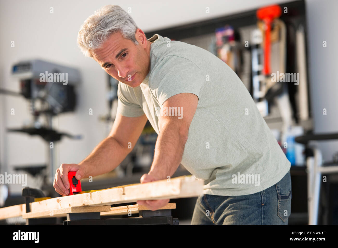 Handwerker, die ein Stück Holz in der Werkstatt messen Stockfoto