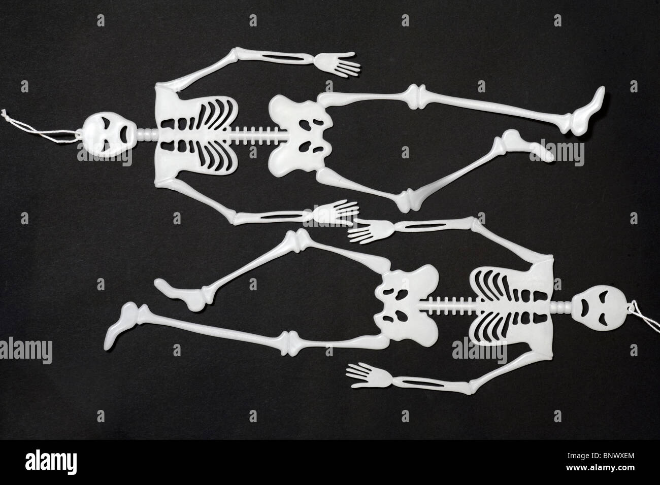 Zwei Skelette von Kopf bis Fuß liegen auf schwarzem Hintergrund - Begriff der Thin skinny magersüchtig Stockfoto