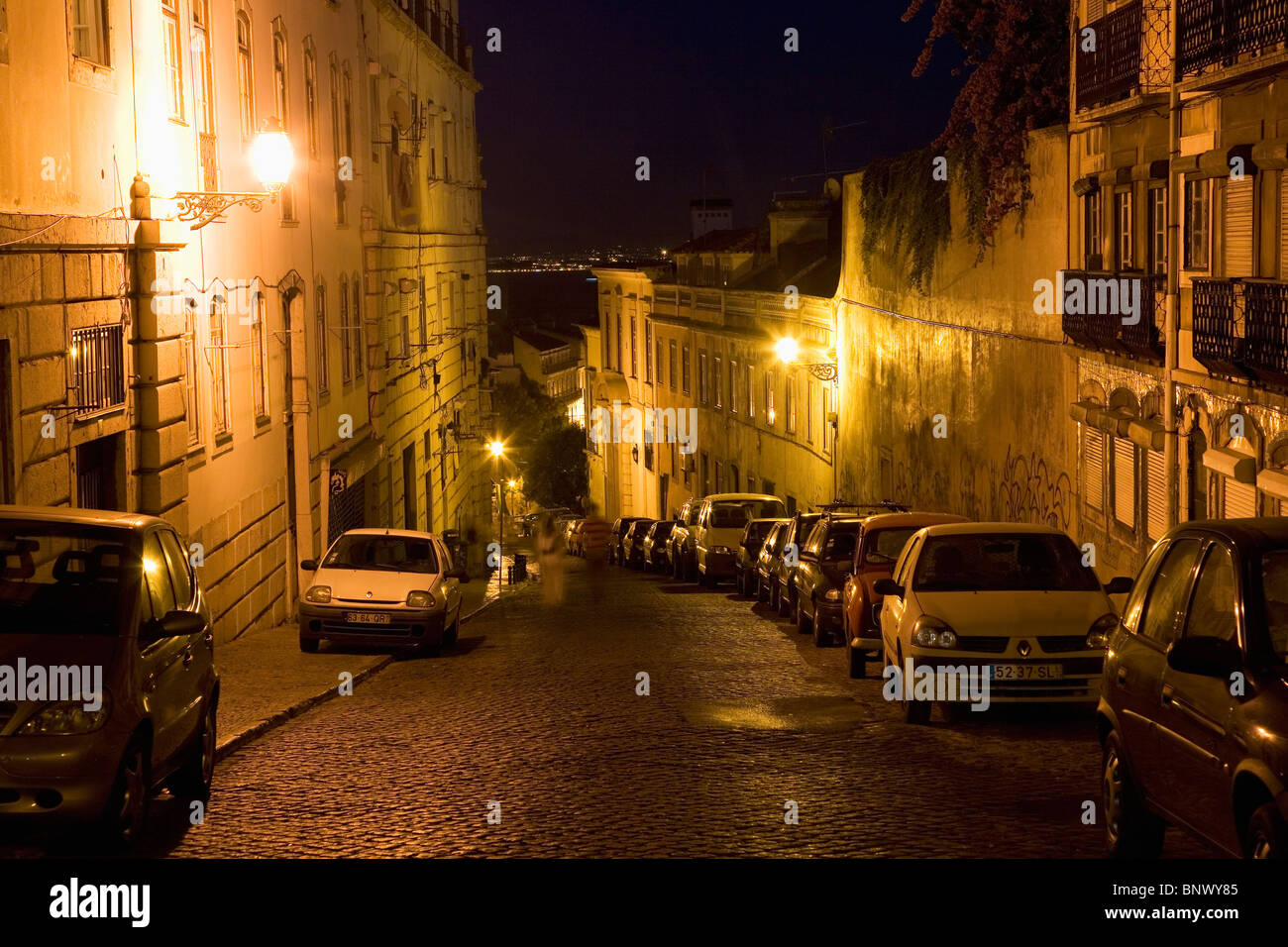 Eine typische Szene des geparkten Autos in der Nacht auf Kopfsteinpflaster in der Alfama Viertel von Lissabon, Portugal. Stockfoto
