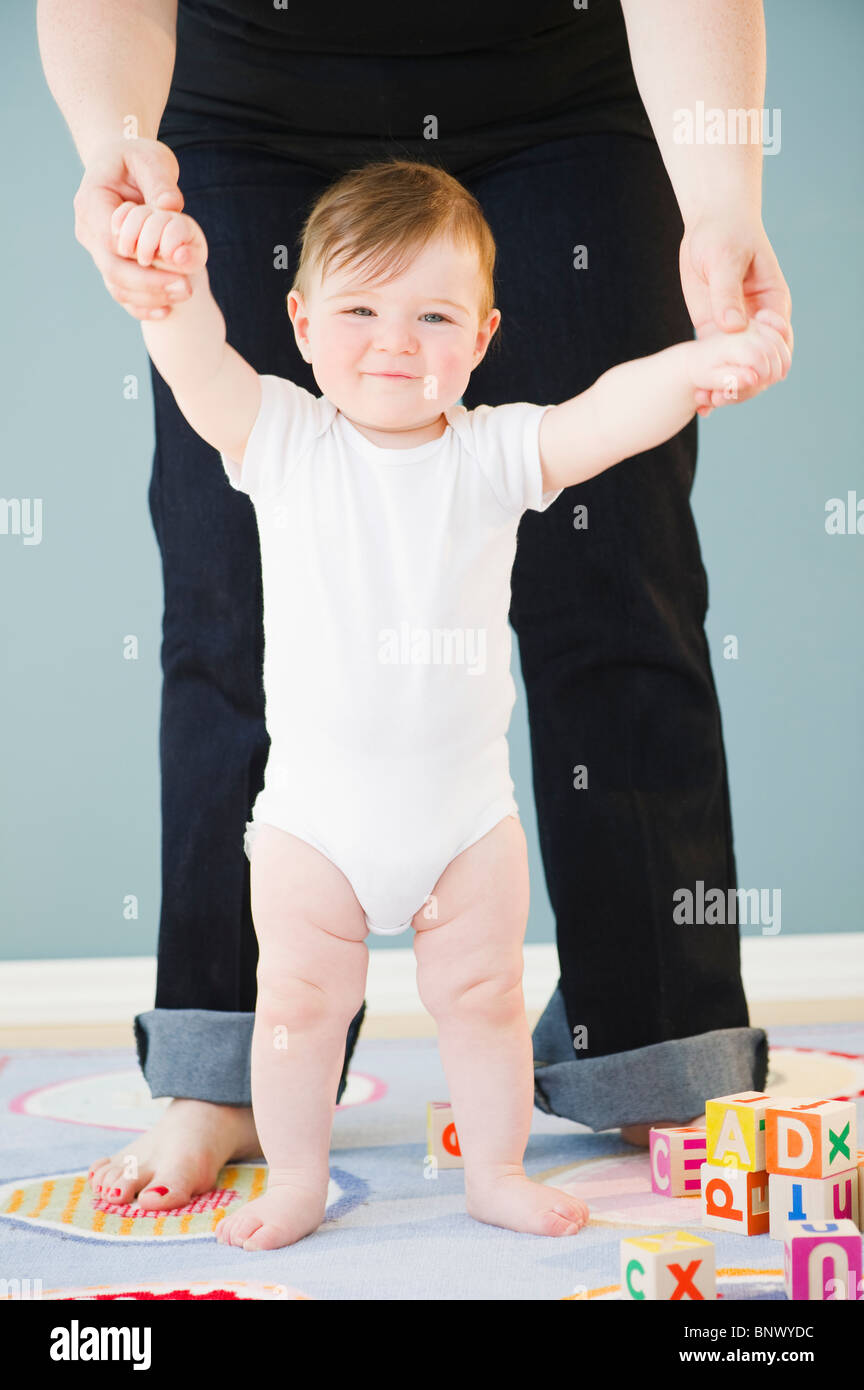 Kleinkind auf Mutters Hände halten Stockfoto