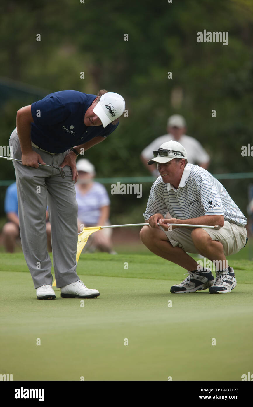 Phil Michelson und Caddie Jim "Bones" MacKay diskutieren einen Putt auf das 12. grün während einer Proberunde der Spieler 2009 Stockfoto