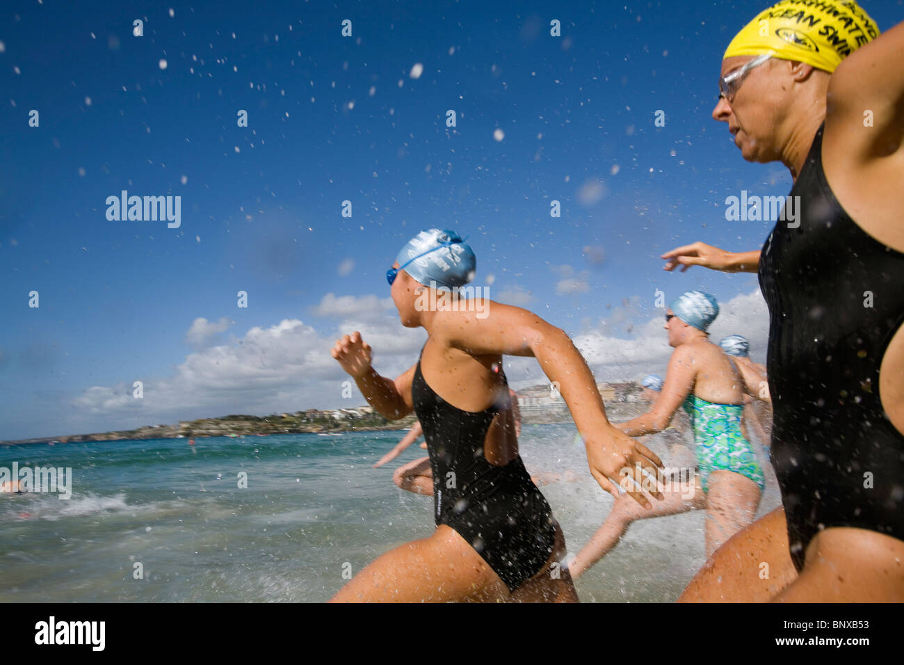 Wettbewerber Sprint für das Wasser während eines Rennens Schwimmen am Bondi Beach. Sydney, New South Wales, Australien Stockfoto