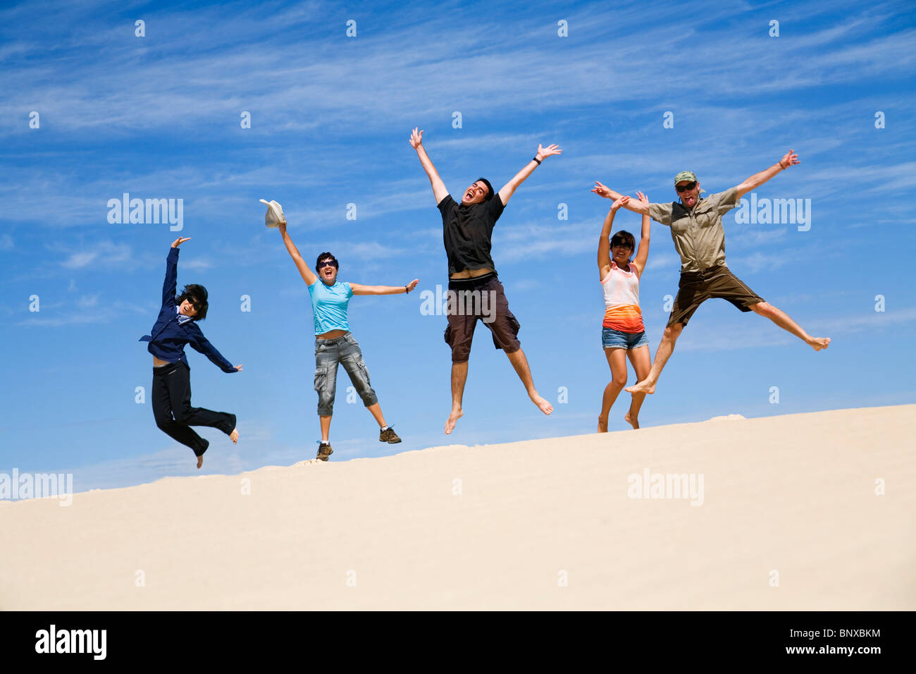 Eine Reisegruppe, die Spaß im Sand der Dünen Henty, in der Nähe von Strahan, Tasmanien, Australien Stockfoto