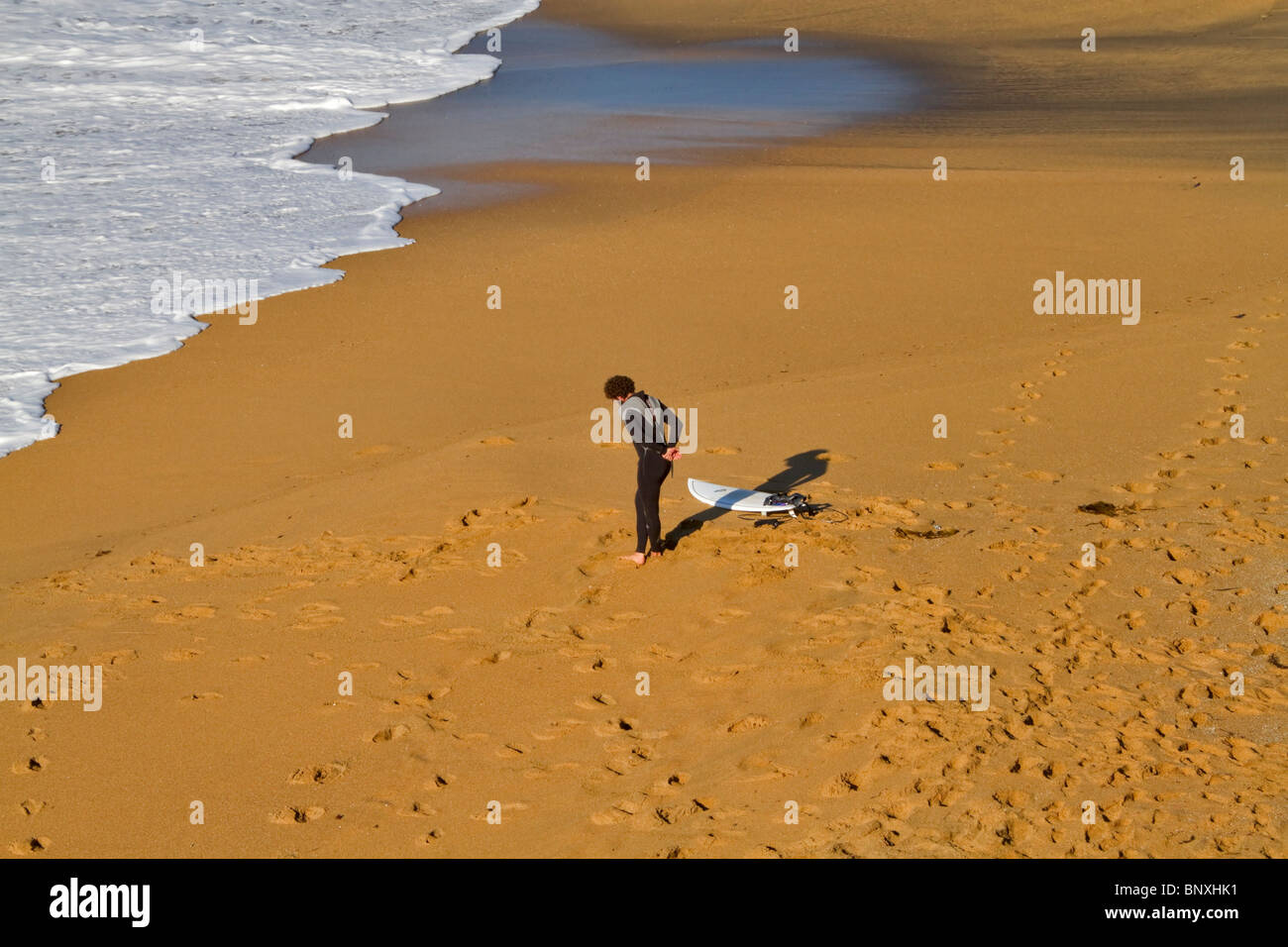 Eine Surfer erwärmt sich mit stretching-Übungen am berühmten Bells Beach, Victoria, Australien Stockfoto