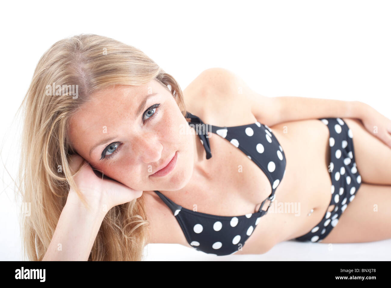 Frau posiert in schwarzen und weißen Bikini auf weißem Hintergrund Stockfoto