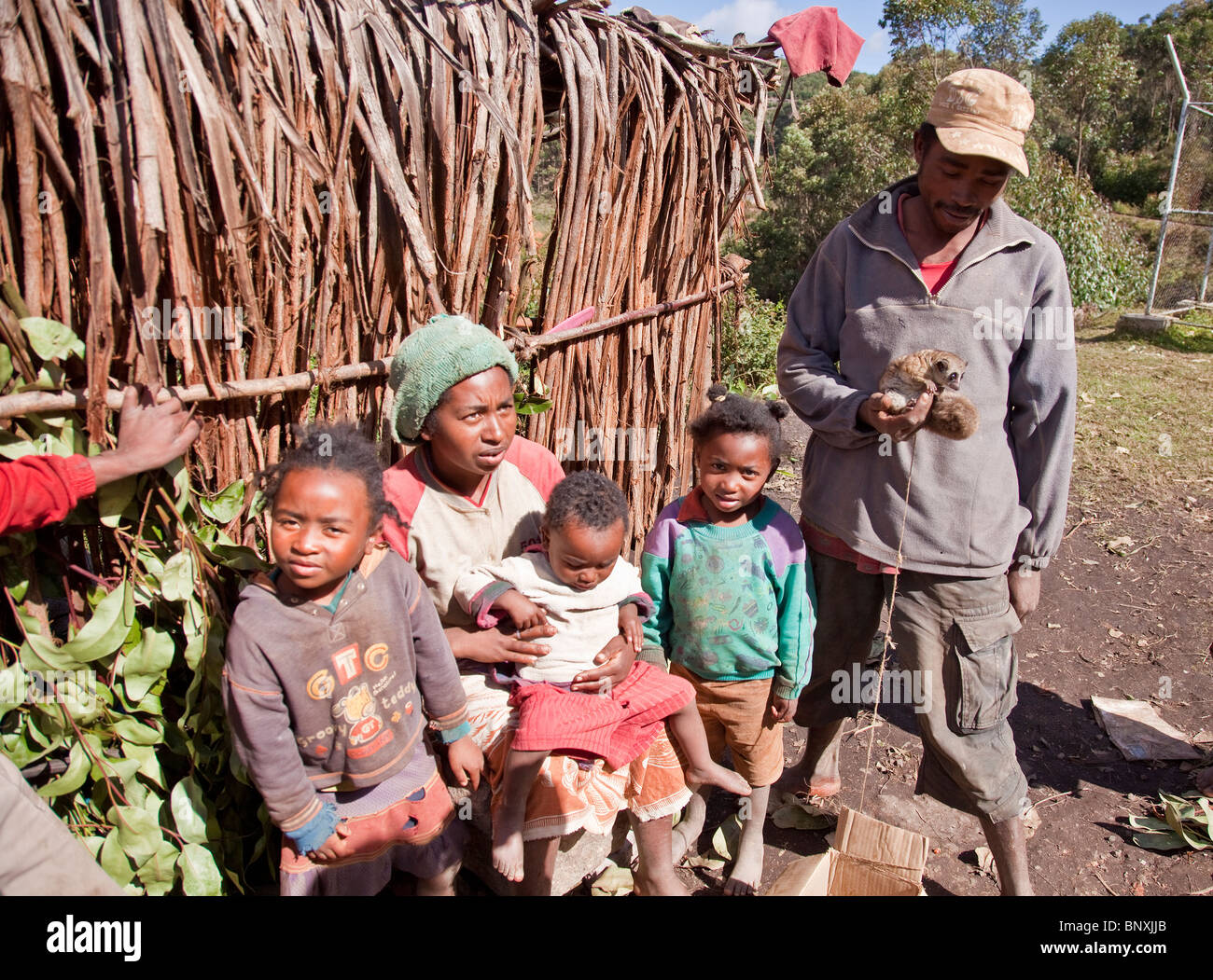 Eine madagassische Familie überleben durch den Verkauf von illegal Lemuren als Buschfleisch. Der Vater hält eine größere Mausmaki zum Verkauf. Stockfoto