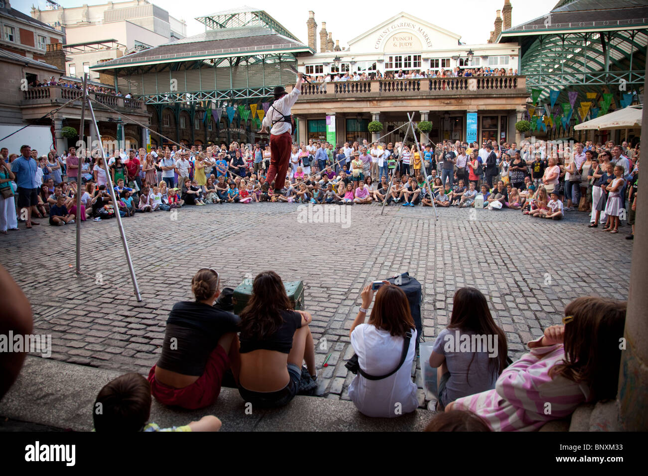 Menschenmassen beobachten die Straßenkünstler in Covent Garden, London, England Stockfoto