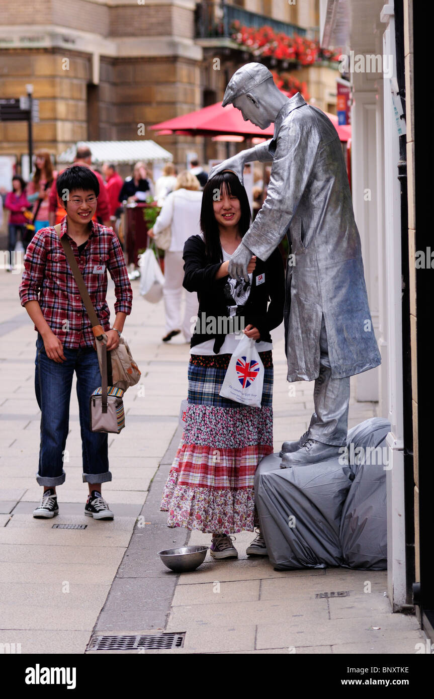 Menschliche Statue Straßenkünstler mit japanischen Touristen, Quecksilber Petty, Cambridge, England, UK Stockfoto