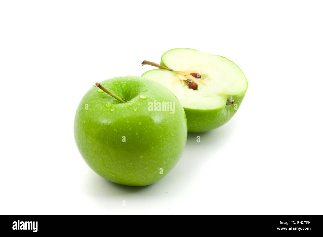 Grüner Apfel ganze und geschnittene in zwei Hälften auf weißem Hintergrund Stockfoto