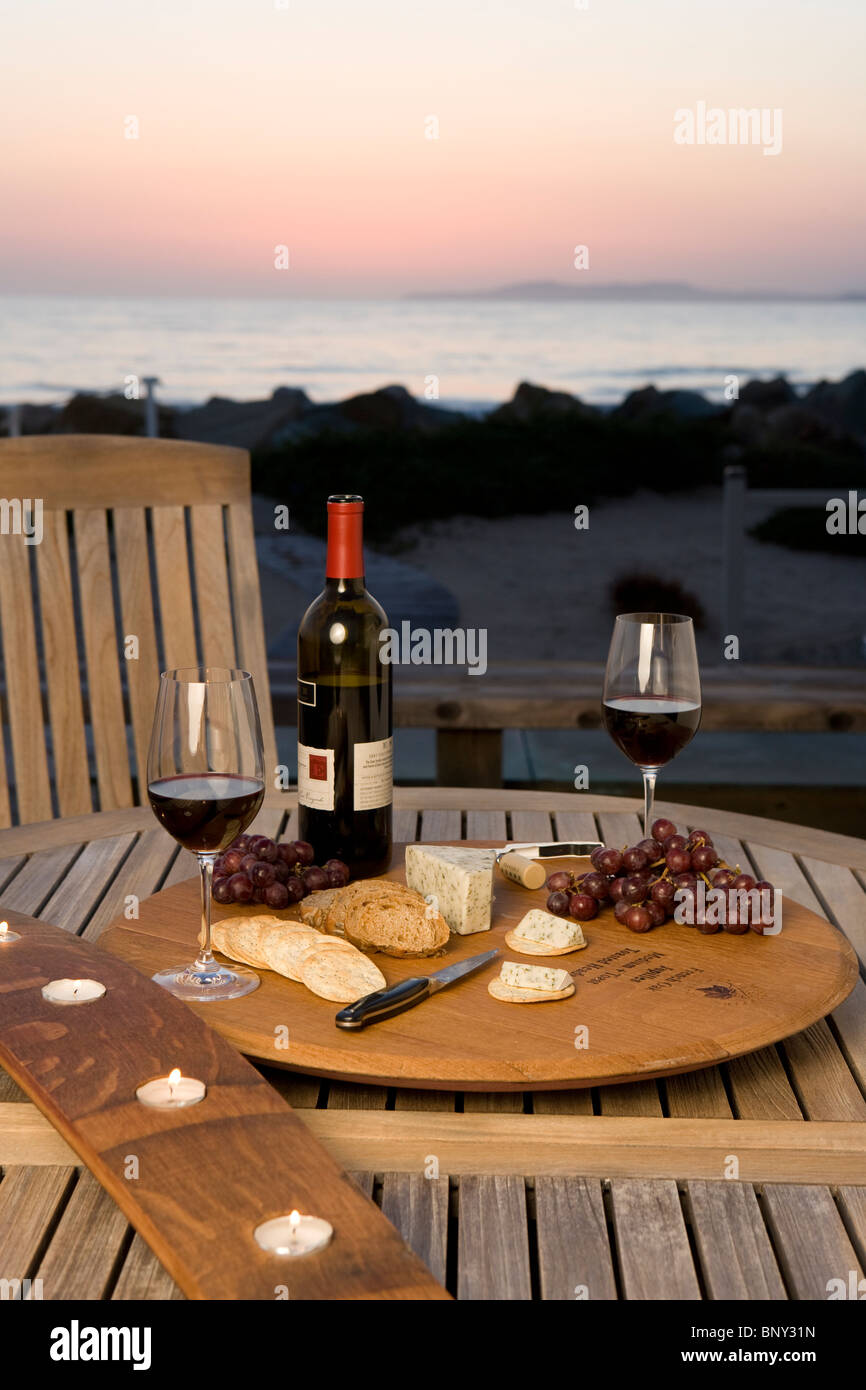 Eine Tischdekoration am Strand für ein Weinfest mit Rotwein, Käse, Cracker. Stockfoto