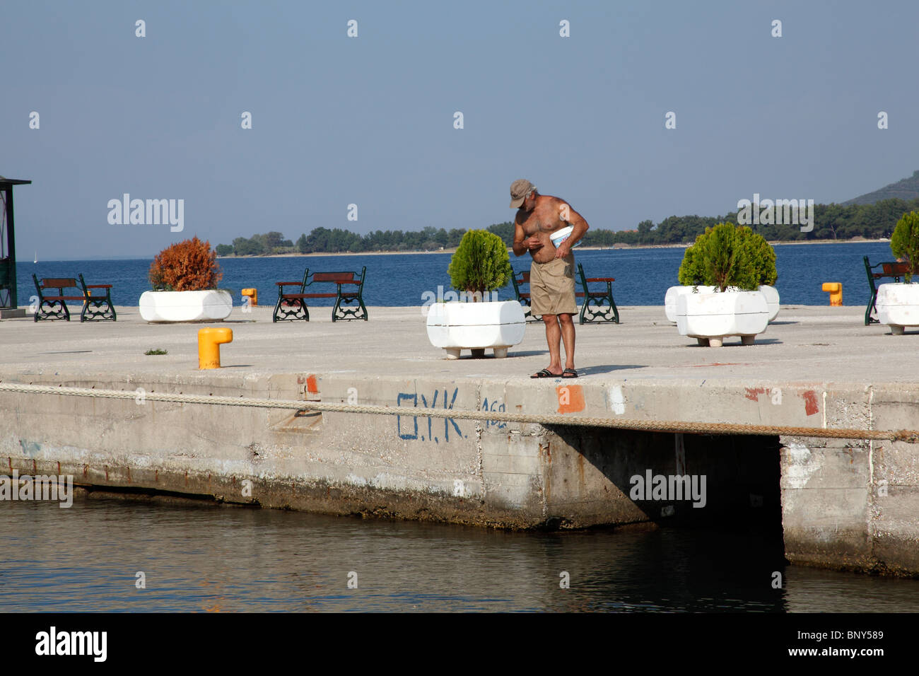 Mann Angeln von einem Pier, Thassos, Griechenland, September 2009 Stockfoto