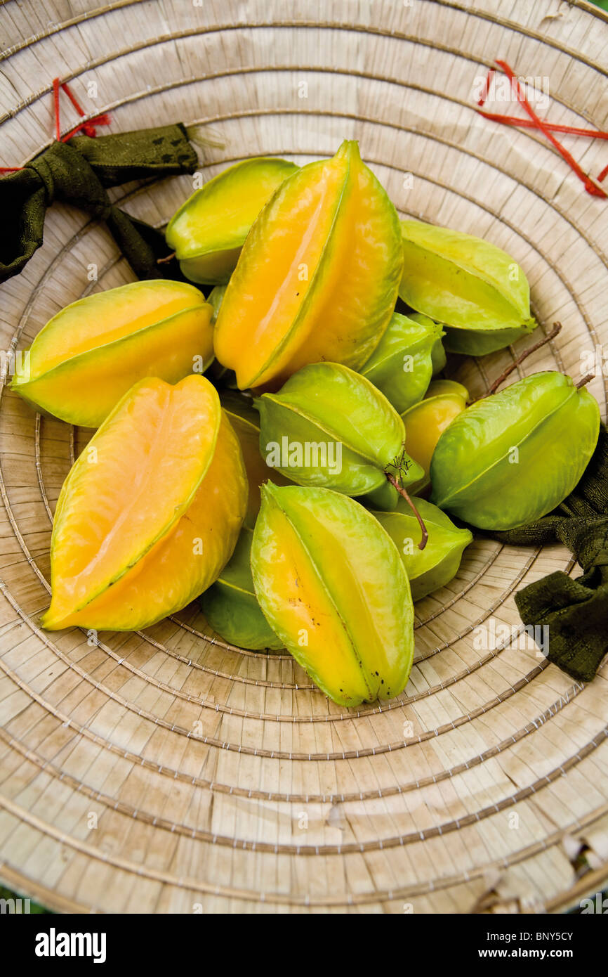 Frisch gepflückt Sternfrüchte in einem traditionellen vietnamesischen Hut Stockfoto