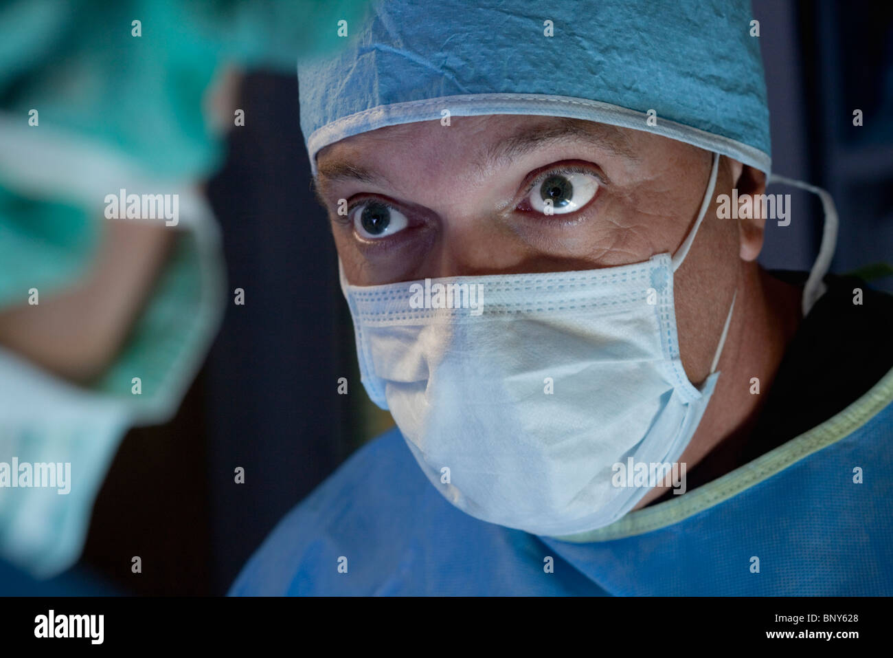 Chirurg betrachten Teammitglied während des Betriebs Stockfoto