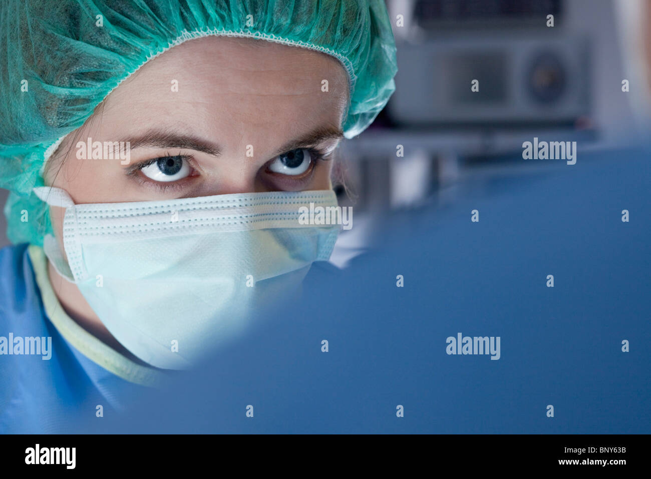 Chirurg betrachten Teammitglied während des Betriebs Stockfoto