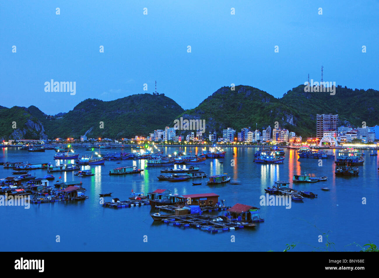 Boote und schwimmende Häuser vor Cat Ba Stadt auf Cat Ba Insel, Vietnam. Stockfoto
