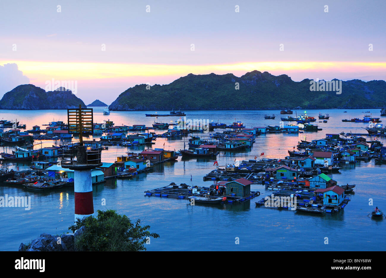 Boote und schwimmende Häuser vor Cat Ba Stadt auf Cat Ba Insel, Vietnam. Stockfoto