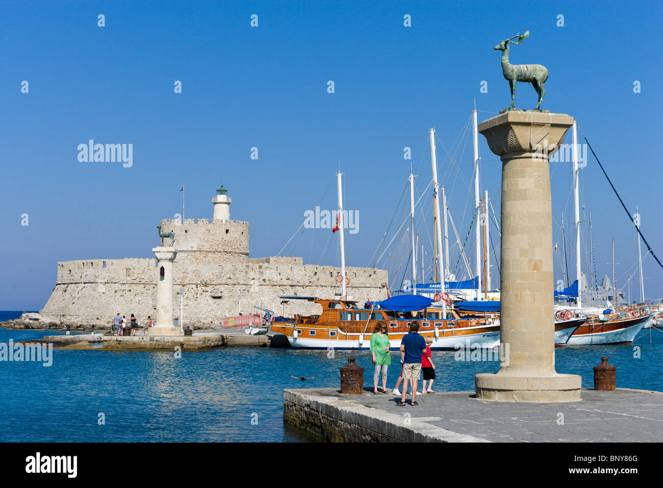 Die alte Festung Agios Nikolaos und Leuchtturm im Hafen von Mandraki mit Hirsch-Statue im Vordergrund, Rhodes Town, Rhodos, Griechenland Stockfoto