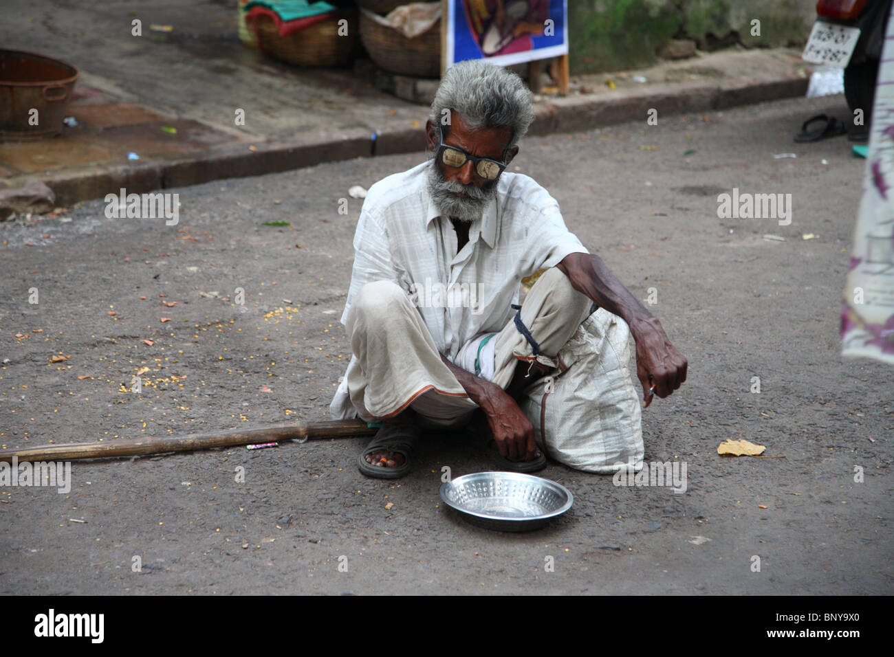 Ein blinder Bettler hocken mit seiner Schale in einer Straße in Kolkata (früher Kalkutta), Indien. Stockfoto