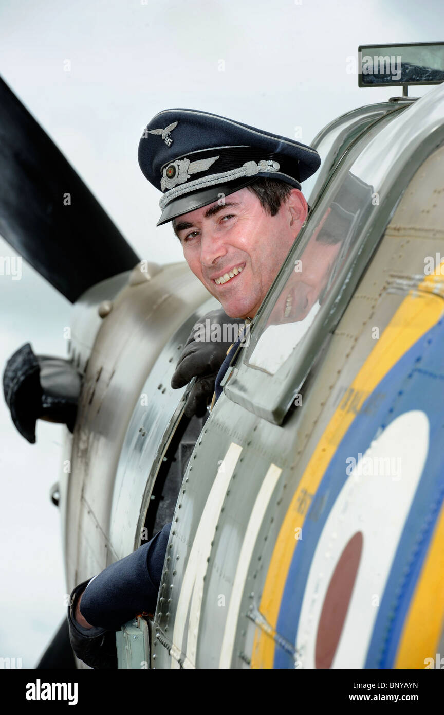 Steve Ricards der Luftwaffe Reinactment Gruppe scheint eine Spitfire in der Luftschlacht um England Dorf an die Roy entführt haben Stockfoto