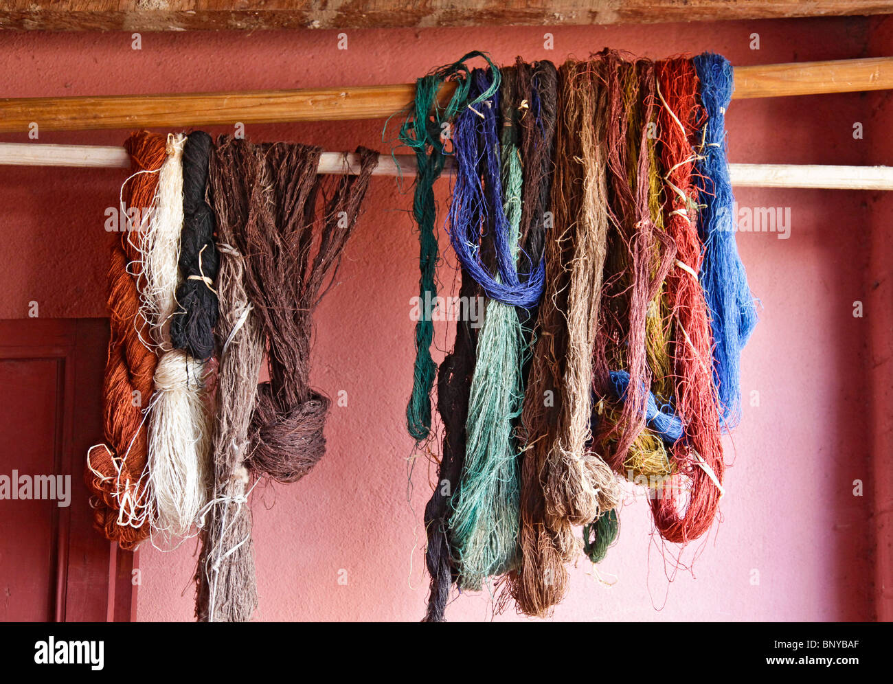 Stränge der natürlich gefärbte Seide Trocknung auf einer Schiene Ambalavao, Haute Matsiatra, Süd-Ost-Madagaskar Stockfoto