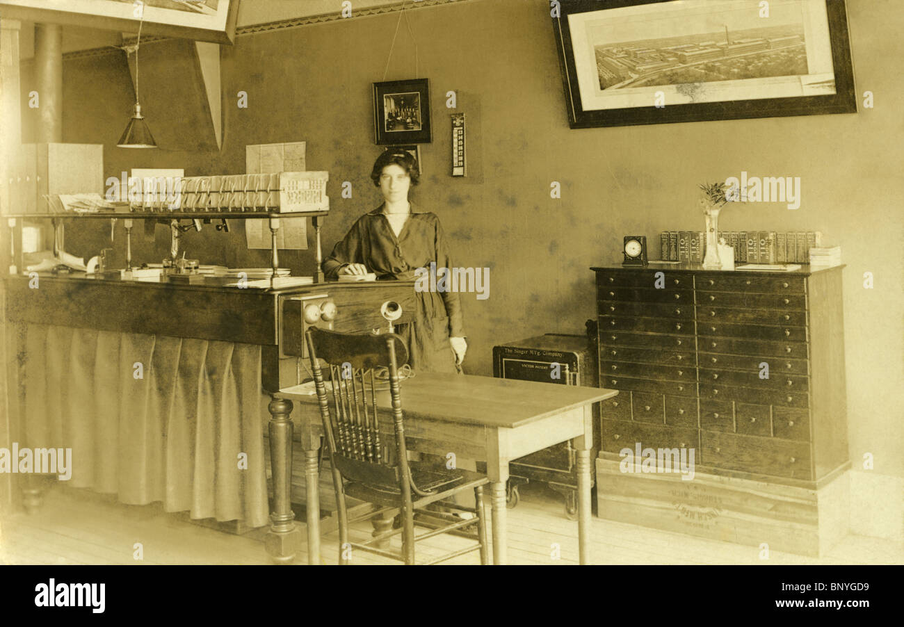 1915-Foto, beschriftet auf Rücken, "Nina Mai bei der Arbeit im Büro Singer-Nähmaschine." Stockfoto