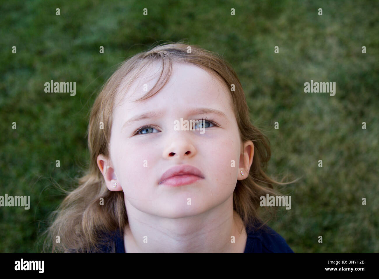 Junges Mädchen spielen im Freien auf dem grünen Rasen Stockfoto