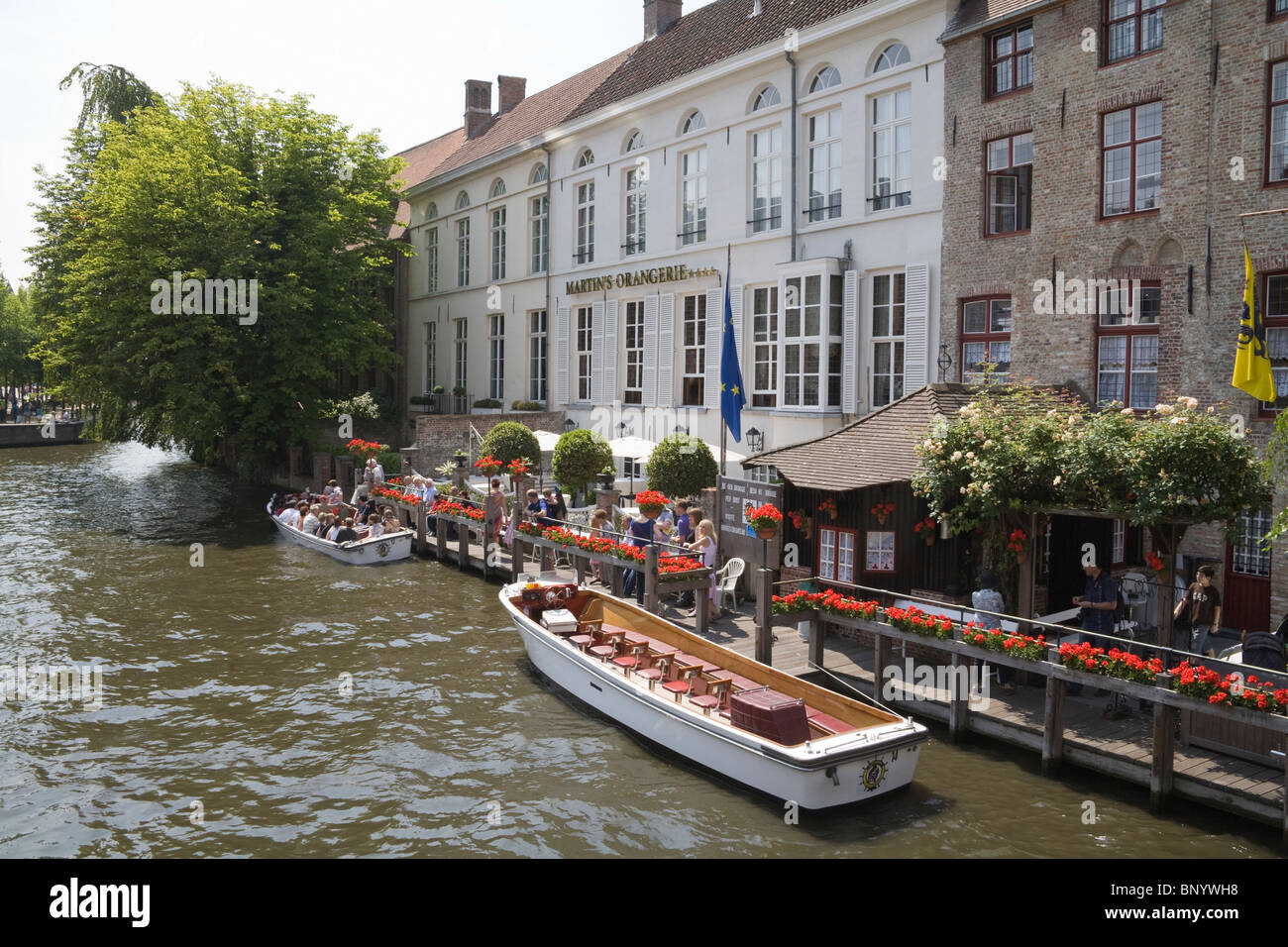 Brügge Belgien Europa EU-Touristen in einem Kanal Kreuzfahrt vor Martins Orangerie Hotel Boot auf dem Fluss Dijver Stockfoto