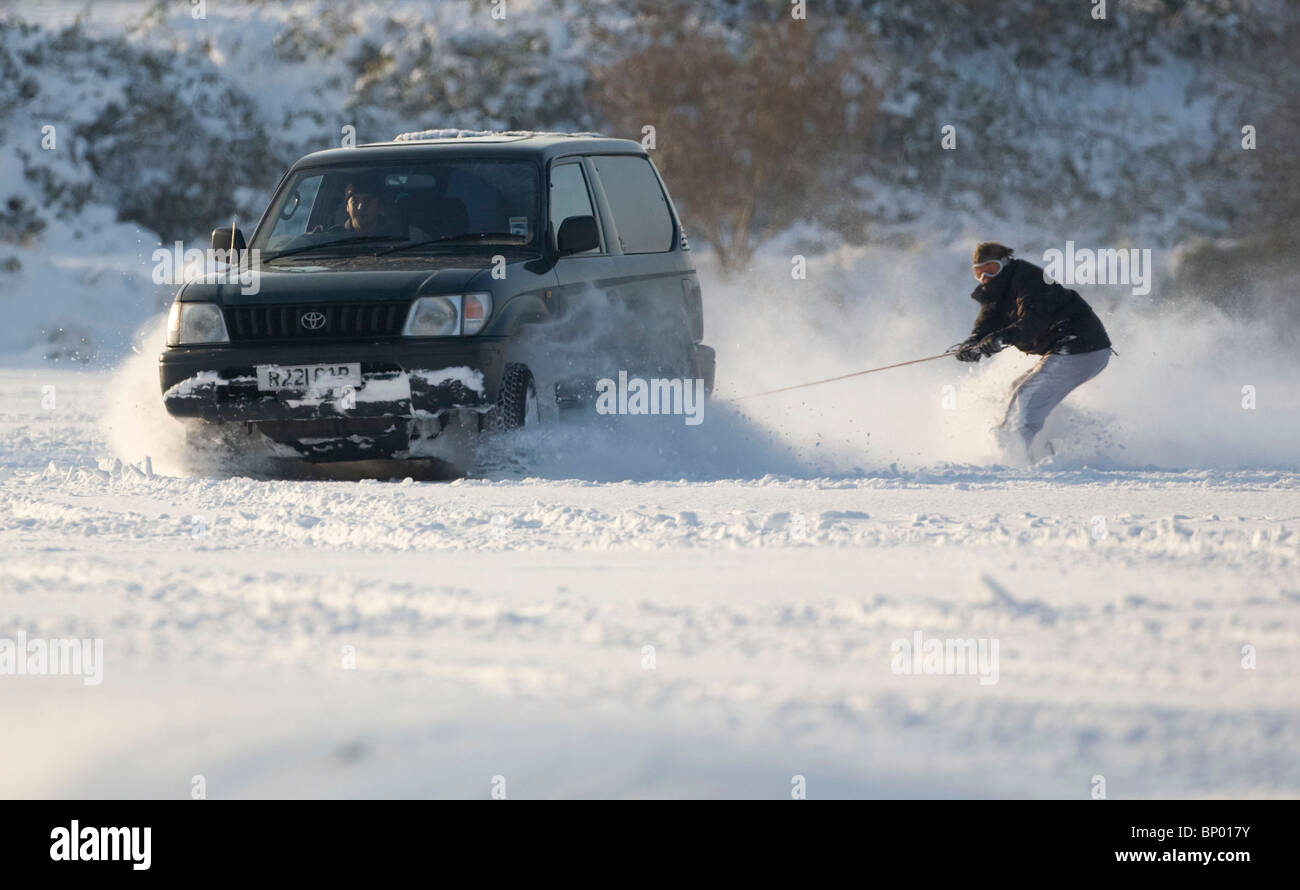 Ein Snowborder wird von einem 4 X 4 durch den dicken Schnee in Brighton geschleppt, nach starker Schneefall auf der südlichen England fiel. Stockfoto