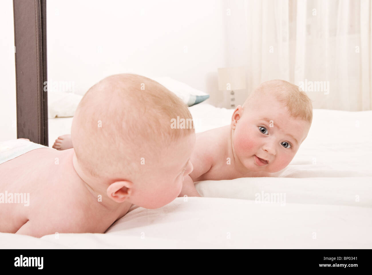 Schöne Aufnahme eines niedlichen Babys in den Spiegel Stockfoto