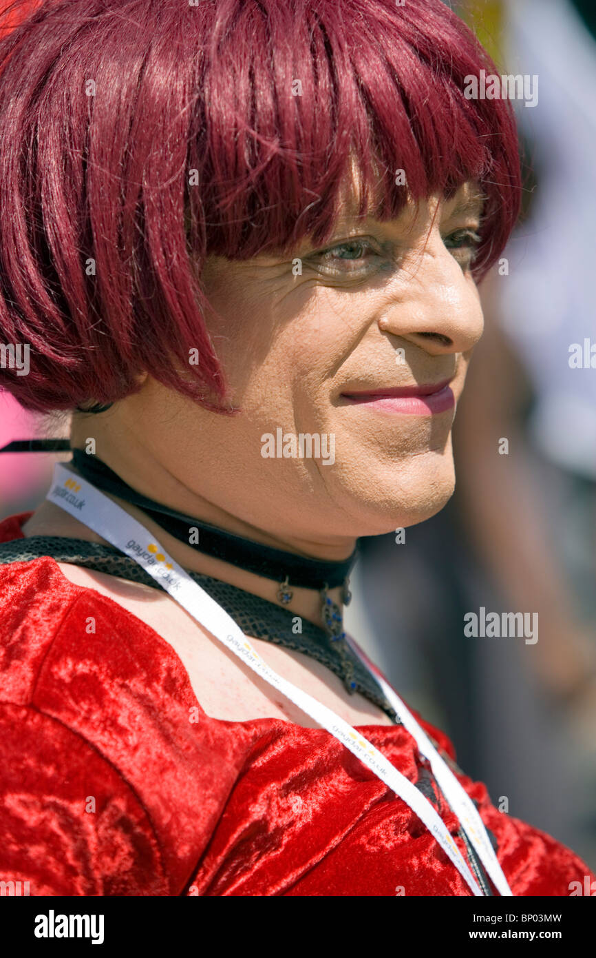 Teilnehmer stellt tragen Make-up, Ingwer Perücke und roten Kleid bei Gay Pride März, Baker Street, London, England, UK, Europa Stockfoto