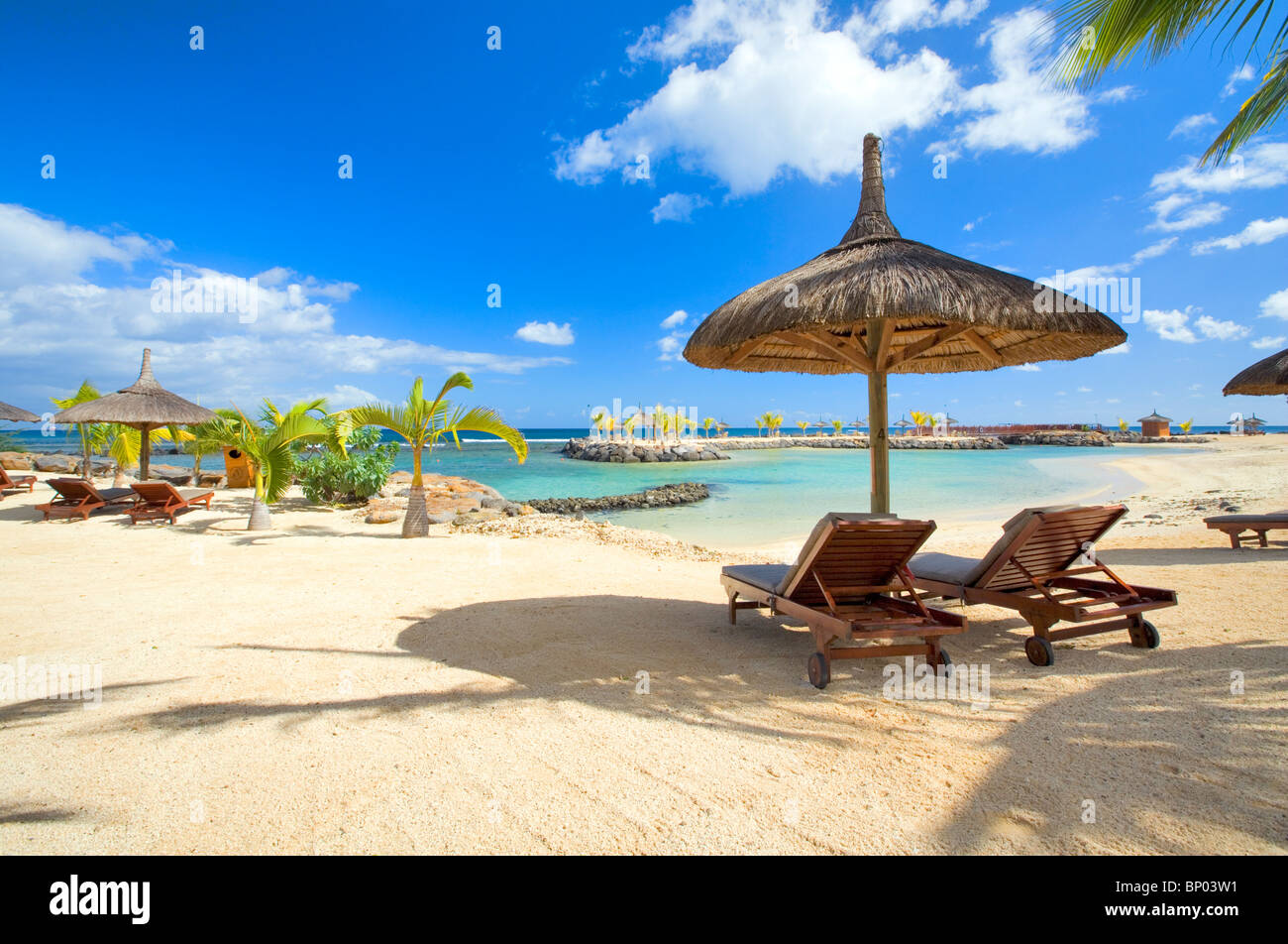 Strand-Szene mit Stroh Sonnenschirme, Mauritius Stockfoto