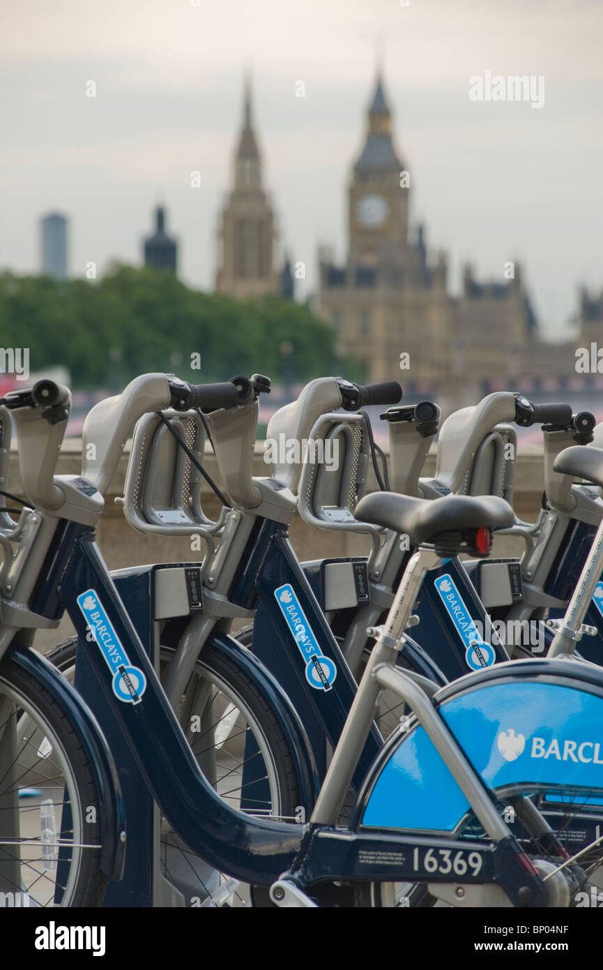 Fahrräder, die Teil der London mieten ein Fahrrad an den Ufern der Themse mit den Houses of Parliament hinter. Stockfoto