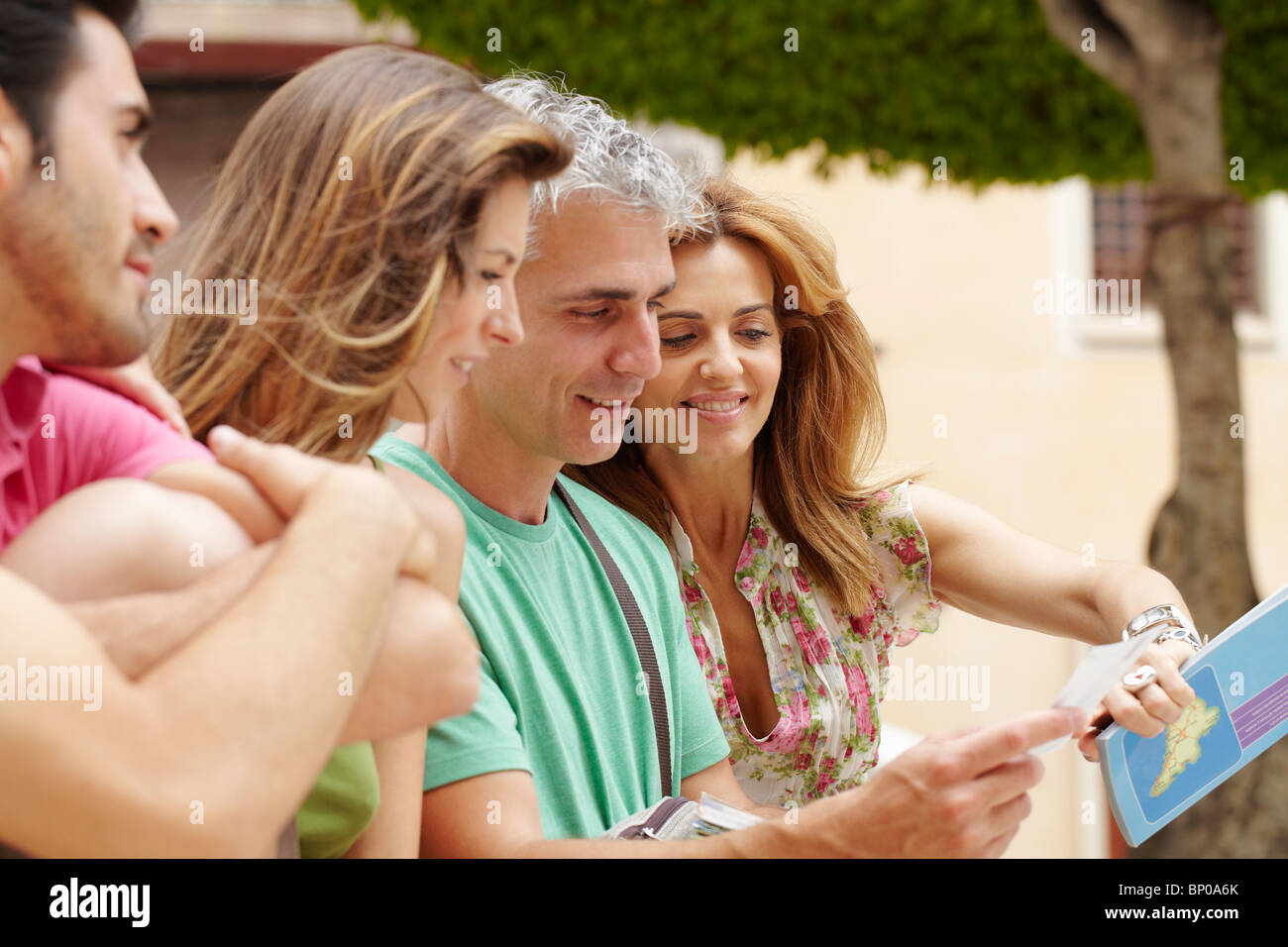 Zwei Paare betrachten Postkarte Stockfoto