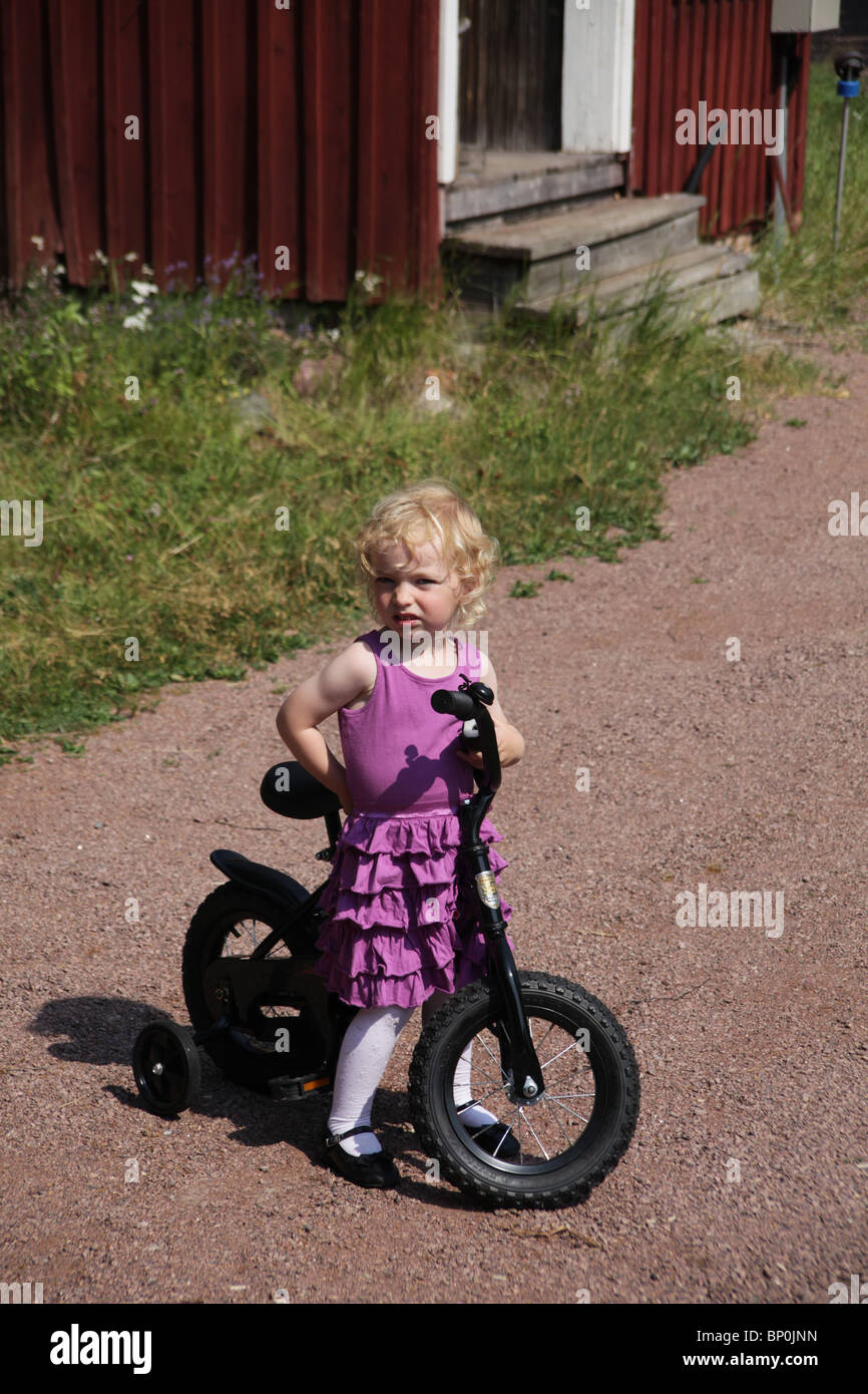 Kleines Mädchen Kleinkind im Party-Kleidung gekleidet sitzen auf einem  Fahrrad Modell veröffentlicht Stockfotografie - Alamy
